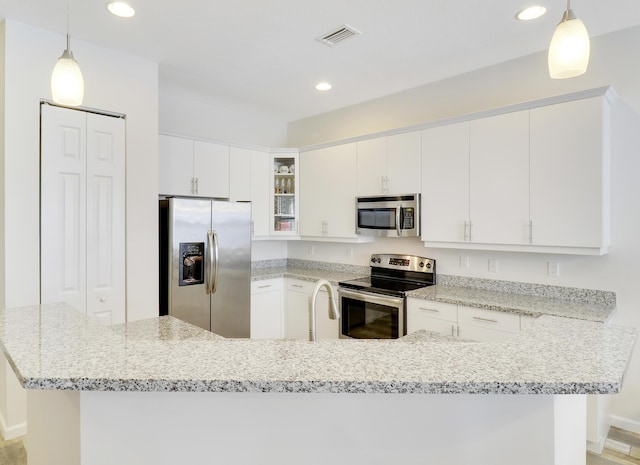 kitchen featuring pendant lighting, white cabinets, and stainless steel appliances