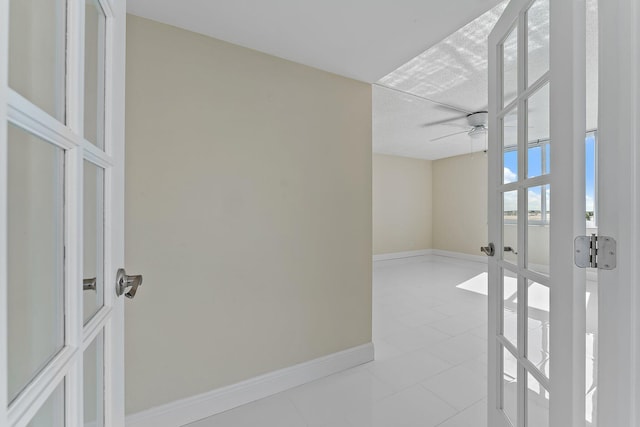 unfurnished room featuring french doors, ceiling fan, and light tile patterned floors