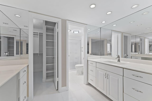 bathroom featuring tile patterned flooring, vanity, toilet, and a shower with shower door