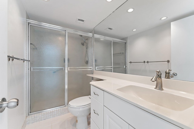 bathroom with vanity, a shower with door, tile patterned flooring, and toilet