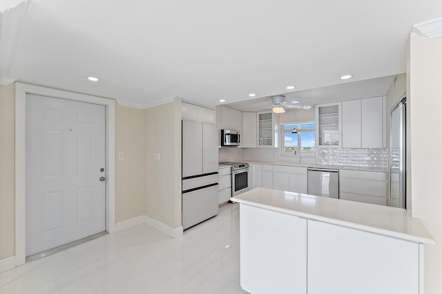 kitchen featuring white cabinetry, decorative backsplash, stainless steel appliances, and sink