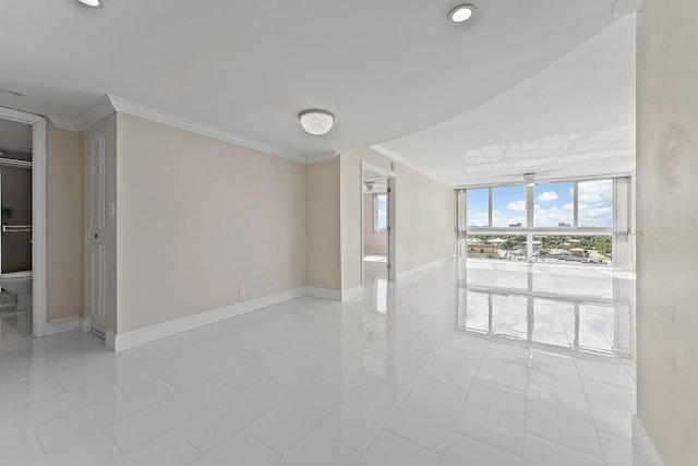 unfurnished room featuring light tile patterned floors and crown molding