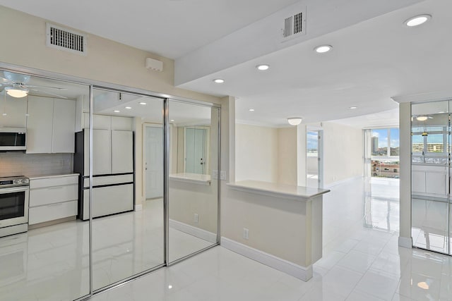 kitchen featuring tasteful backsplash, white cabinetry, and appliances with stainless steel finishes