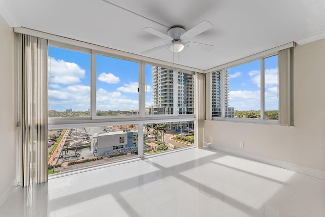 unfurnished sunroom with ceiling fan