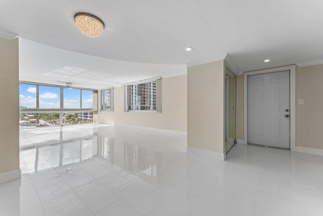 tiled empty room with expansive windows and crown molding