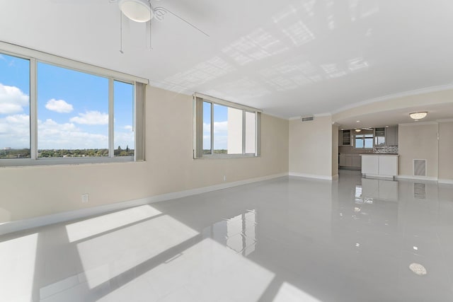 unfurnished room with ornamental molding, a wealth of natural light, and tile patterned floors