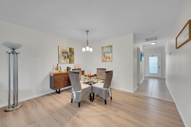 dining area featuring a notable chandelier and light wood-type flooring