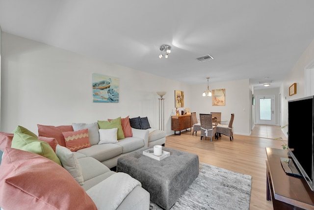 living room featuring light hardwood / wood-style floors and an inviting chandelier