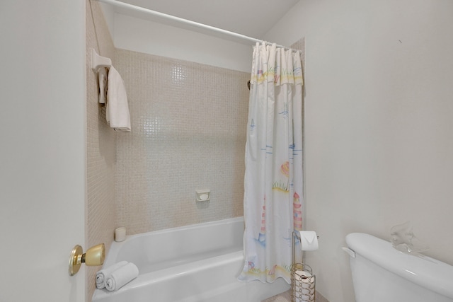 bathroom featuring toilet and shower / tub combo with curtain