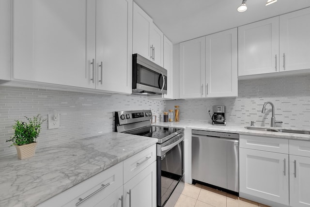 kitchen with white cabinetry, sink, light tile patterned flooring, and appliances with stainless steel finishes