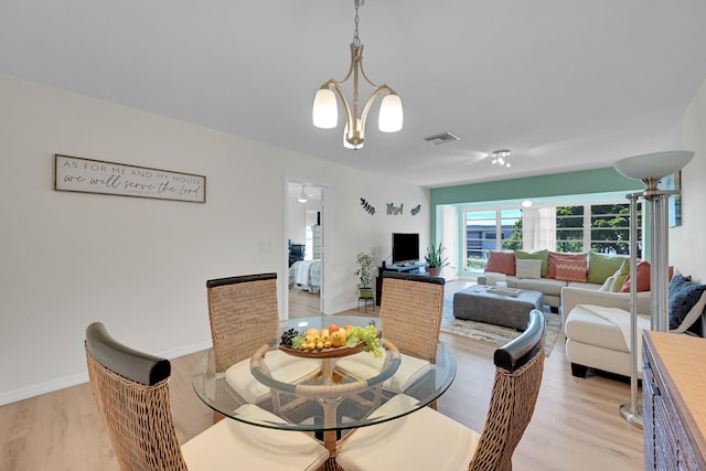 dining area featuring an inviting chandelier and light hardwood / wood-style flooring