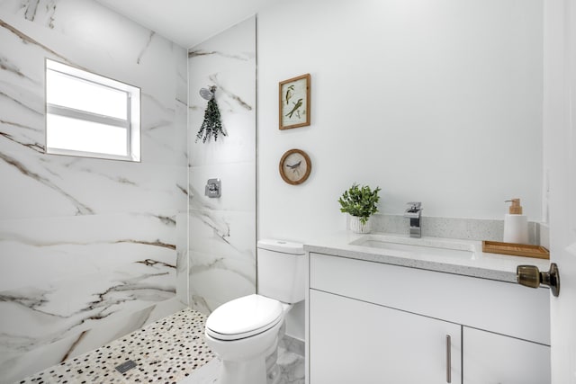 bathroom with a marble finish shower, toilet, marble finish floor, and vanity