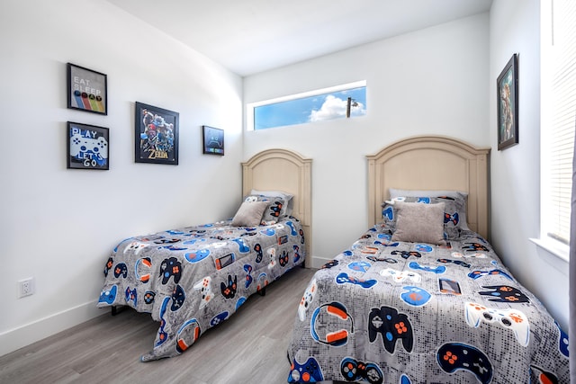 bedroom featuring baseboards and wood finished floors