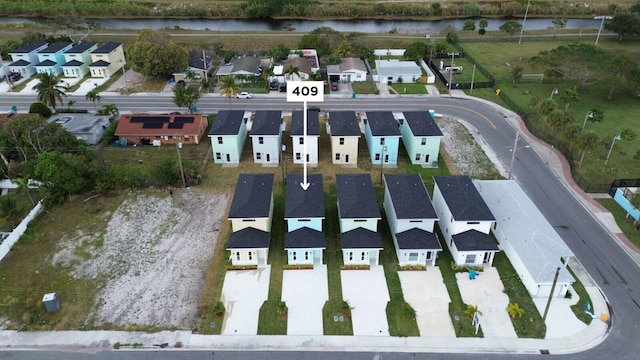 drone / aerial view featuring a residential view and a water view