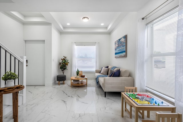 sitting room featuring a wealth of natural light, recessed lighting, stairs, and a tray ceiling