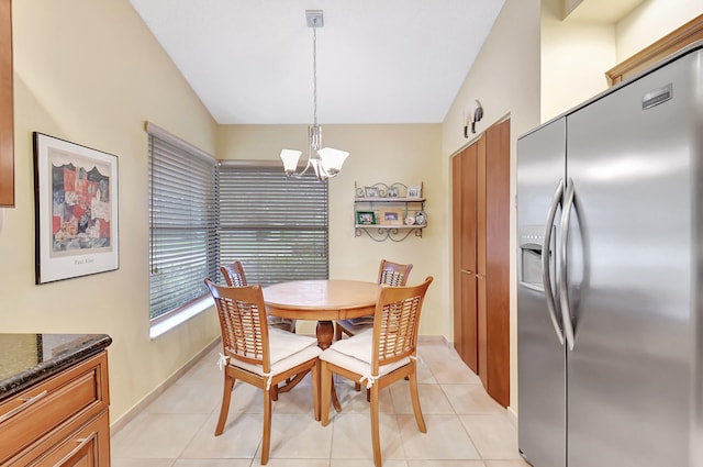 tiled dining area with lofted ceiling and a notable chandelier