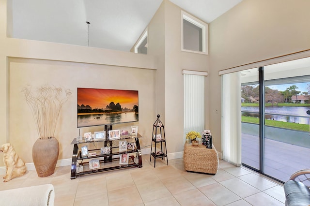 living area with tile patterned floors and a high ceiling