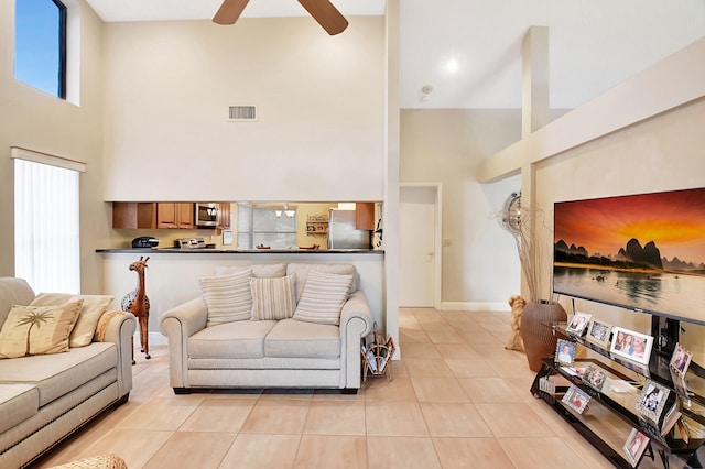 tiled living room featuring a high ceiling and ceiling fan