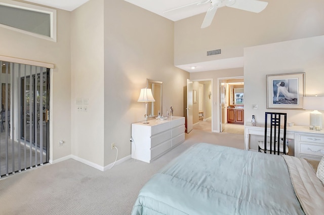 bedroom featuring a high ceiling, light colored carpet, and ceiling fan