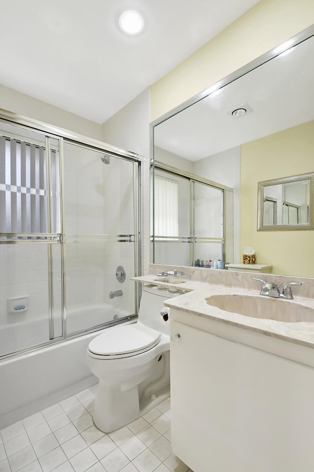 full bathroom with vanity, bath / shower combo with glass door, toilet, and tile patterned flooring