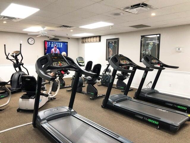 gym with a drop ceiling and ceiling fan