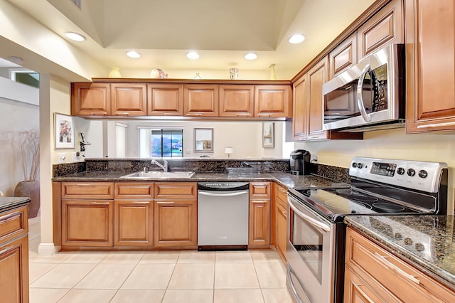 kitchen featuring light tile patterned floors, appliances with stainless steel finishes, sink, and dark stone counters