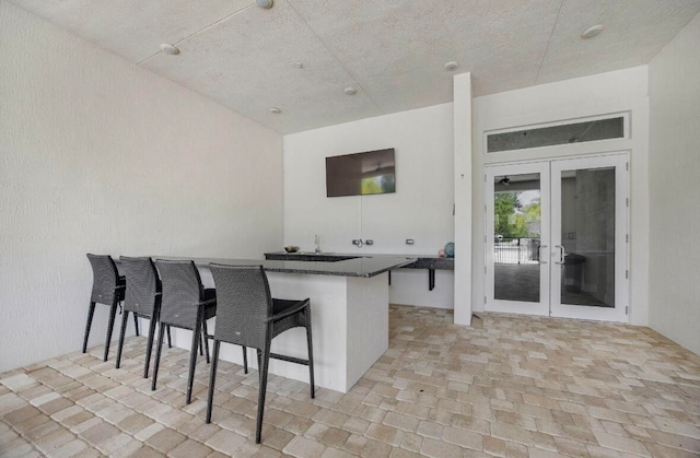 kitchen with kitchen peninsula, a breakfast bar area, and french doors