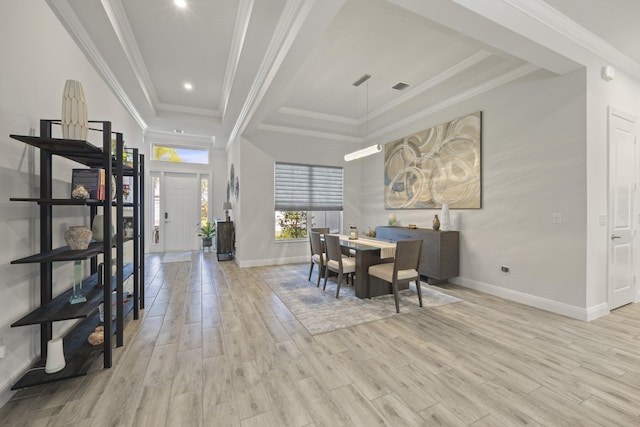 dining area featuring light wood-type flooring and crown molding