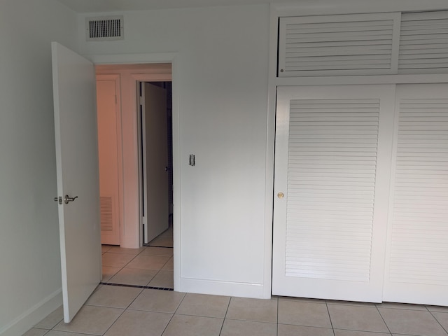 unfurnished bedroom with a closet and light tile patterned floors