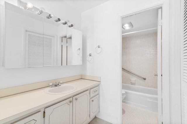 full bathroom with tile patterned flooring, vanity, tiled shower / bath combo, and toilet