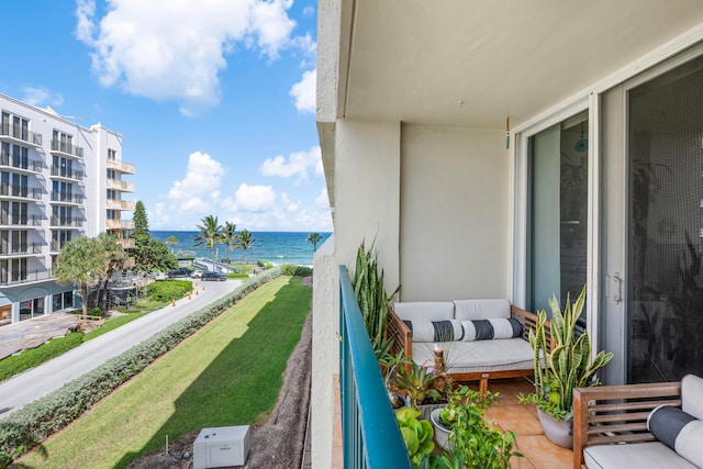 balcony featuring a water view and an outdoor living space