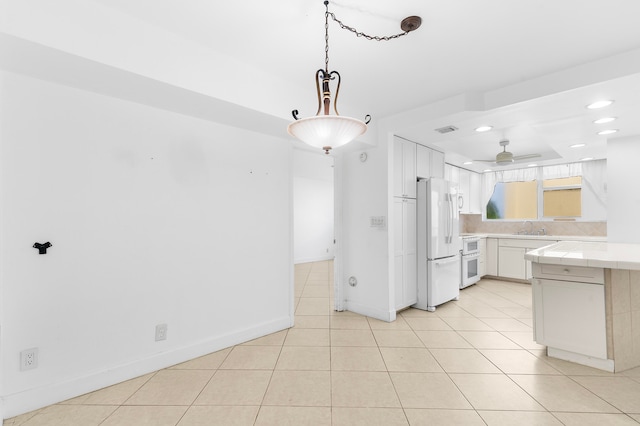 kitchen with tile countertops, sink, light tile patterned floors, white cabinetry, and white appliances