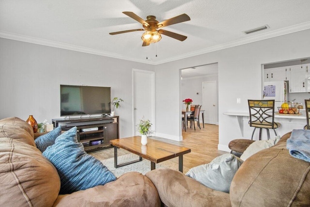 living room featuring crown molding, light hardwood / wood-style flooring, and ceiling fan