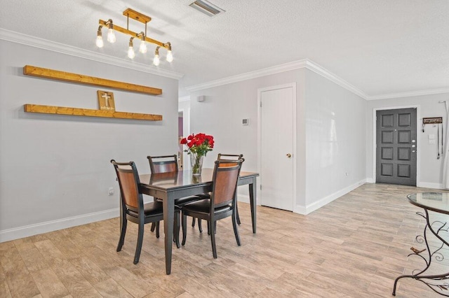 dining area featuring light hardwood / wood-style floors, crown molding, and a textured ceiling