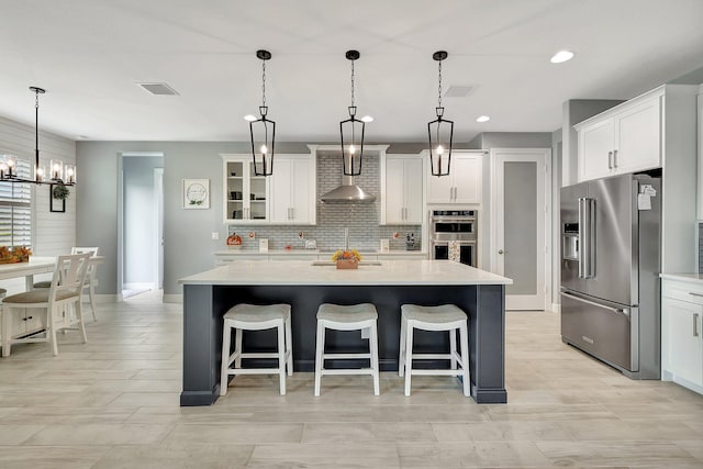 kitchen featuring pendant lighting, white cabinets, and appliances with stainless steel finishes