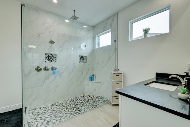 bathroom featuring tiled shower and vanity