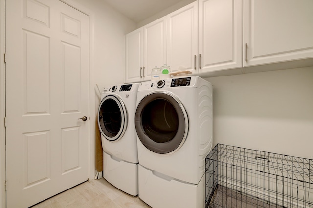 laundry area with independent washer and dryer and cabinets