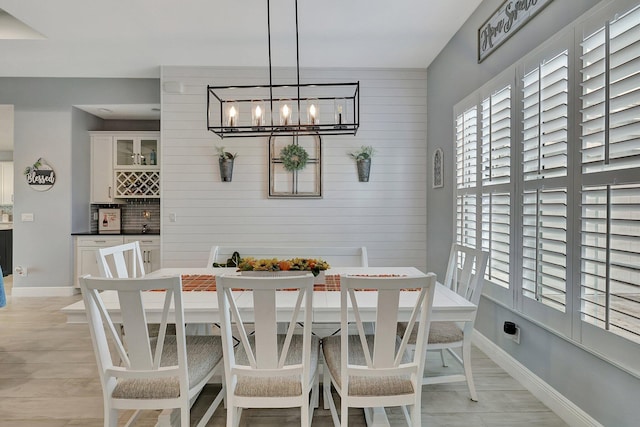 tiled dining space with wooden walls and a chandelier