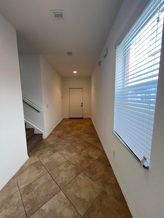 hall with light tile patterned floors