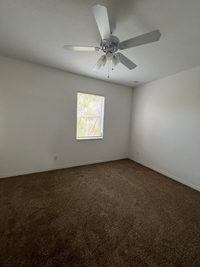 empty room featuring dark carpet and ceiling fan