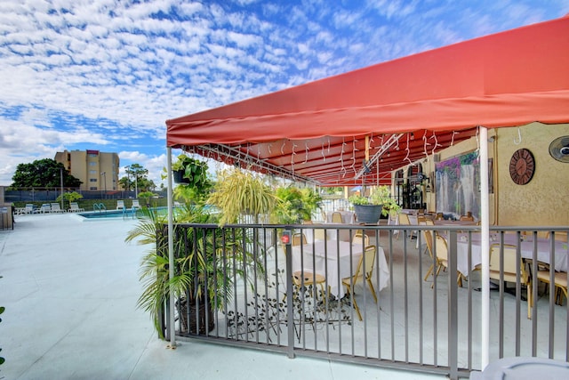 view of gate featuring a community pool and a patio