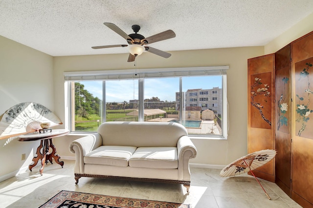 sitting room featuring ceiling fan and a textured ceiling