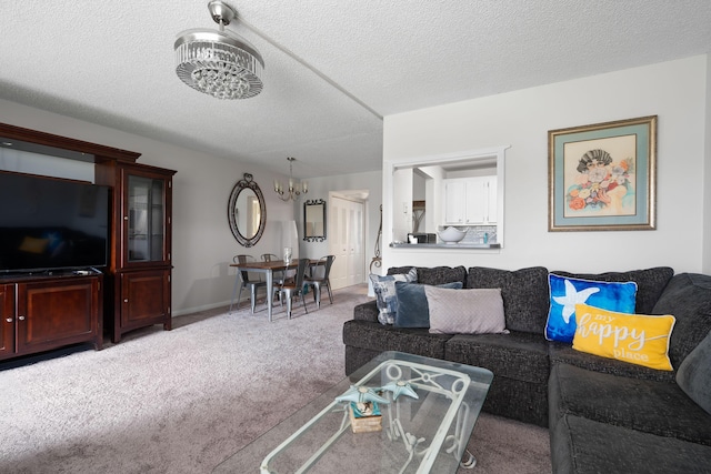 carpeted living room with a textured ceiling and a notable chandelier