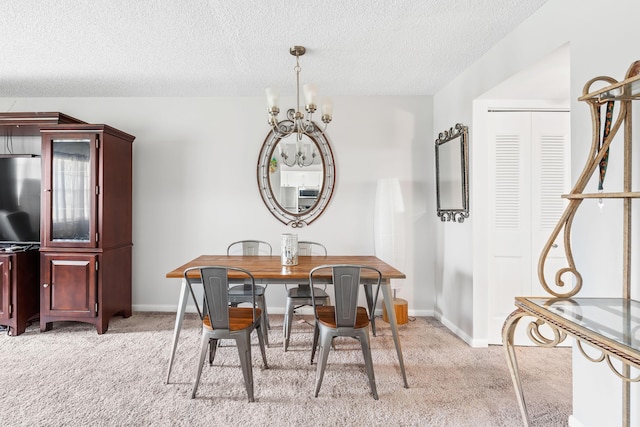 dining space with baseboards, light carpet, a notable chandelier, and a textured ceiling