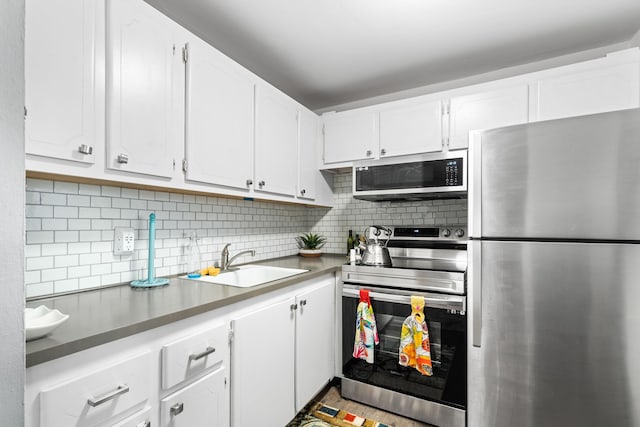 kitchen featuring appliances with stainless steel finishes, backsplash, white cabinetry, and sink