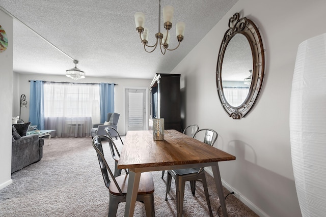 carpeted dining space featuring a notable chandelier and a textured ceiling