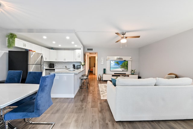 living room featuring ceiling fan and light wood-type flooring