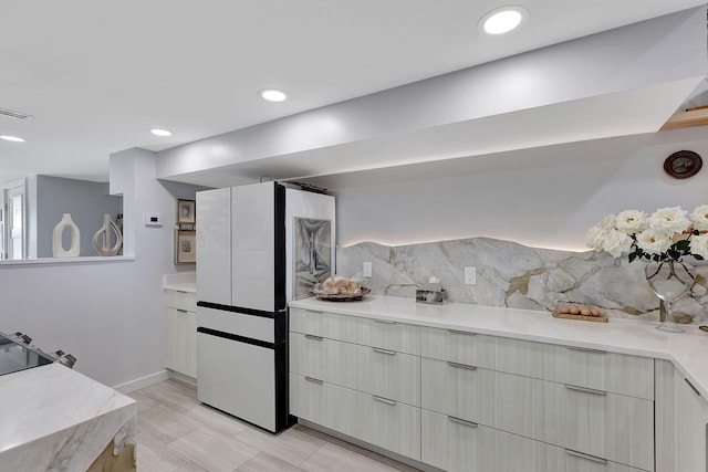 interior space with light stone counters, light hardwood / wood-style flooring, decorative light fixtures, black electric stovetop, and sink