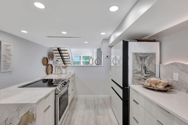 kitchen with backsplash, light stone countertops, white fridge, a center island, and black electric stovetop