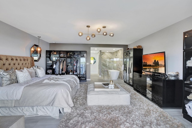 bedroom with an inviting chandelier, light hardwood / wood-style floors, access to outside, and a wall mounted air conditioner